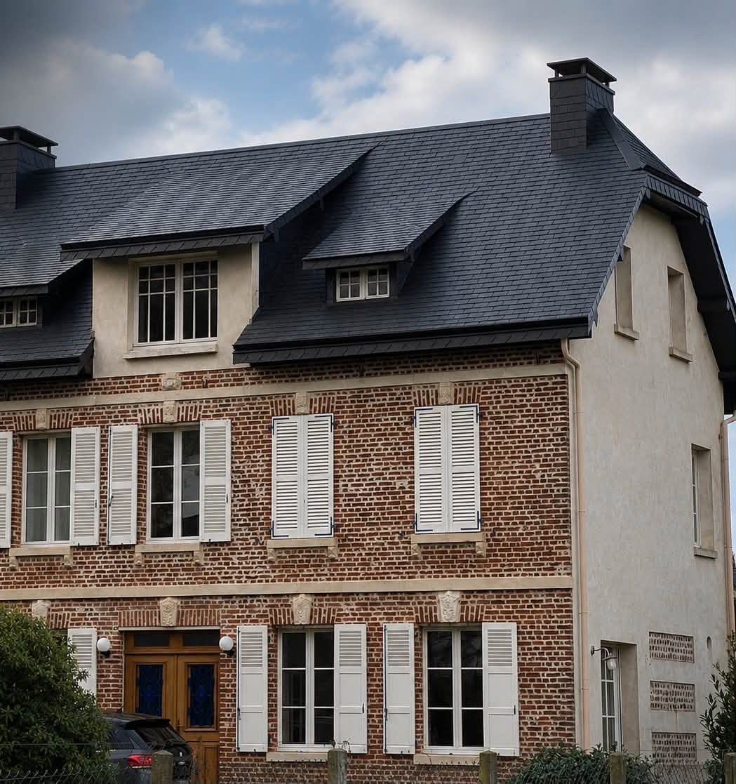 Toiture en ardoise avec trois lucarnes refaite sur une maison en brique